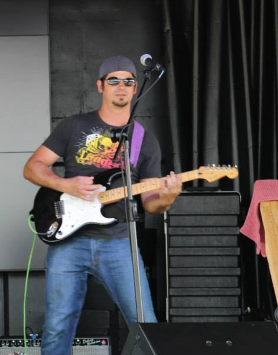 David Marshall playing electric guitar onstage at a microphone